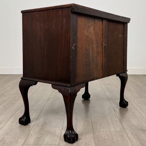 fig 3. A dark mahogany chest of drawers featuring three long drawers with brass handles, raised on carved cabriole legs ending in ball and claw feet.