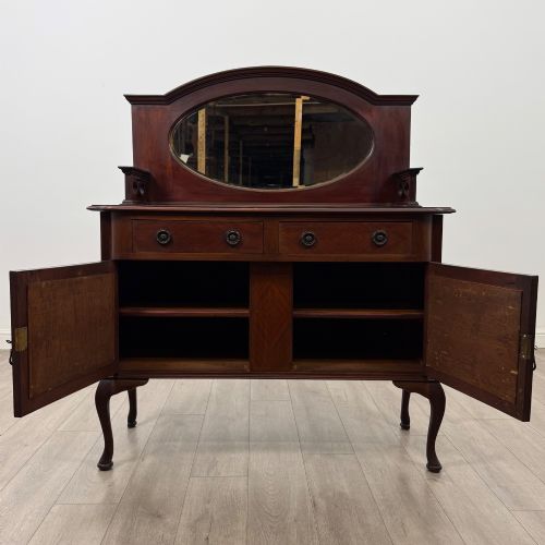 fig 1. An antique Edwardian mahogany sideboard featuring a top section with a central oval mirror, two drawers, and a two-door cabinet below raised on cabriole legs.