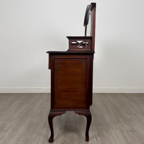 fig 3. An antique Edwardian mahogany sideboard featuring a top section with a central oval mirror, two drawers, and a two-door cabinet below raised on cabriole legs.