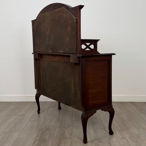 fig 6. An antique Edwardian mahogany sideboard featuring a top section with a central oval mirror, two drawers, and a two-door cabinet below raised on cabriole legs.