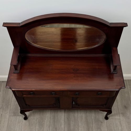 fig 9. An antique Edwardian mahogany sideboard featuring a top section with a central oval mirror, two drawers, and a two-door cabinet below raised on cabriole legs.