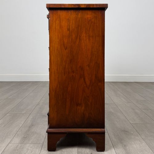 fig 3. An antique 20th-century small breakfront sideboard with figured burr walnut veneers, brass drop handles, four central drawers, and side cupboard doors.