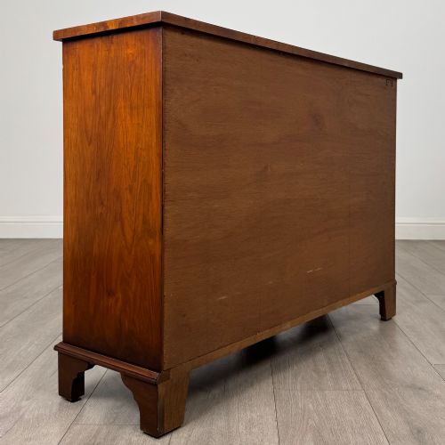fig 4. An antique 20th-century small breakfront sideboard with figured burr walnut veneers, brass drop handles, four central drawers, and side cupboard doors.