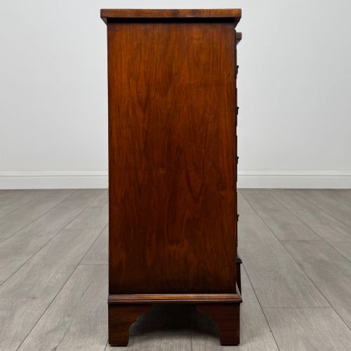 fig 7. An antique 20th-century small breakfront sideboard with figured burr walnut veneers, brass drop handles, four central drawers, and side cupboard doors.