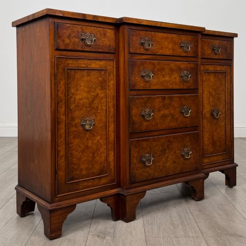 fig 8. An antique 20th-century small breakfront sideboard with figured burr walnut veneers, brass drop handles, four central drawers, and side cupboard doors.