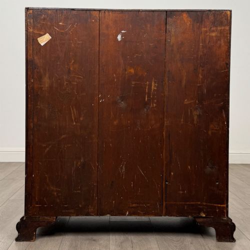 fig 5. An 18th-century Georgian mahogany bureau featuring a sloped fall-front lid, brass batwing handles and escutcheons, three graduated drawers, and bracket feet.