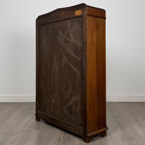 fig 6. A twin-door dark oak display cabinet featuring leaded glass upper panels, carved decorative lower panels, and ornate metal hinges.