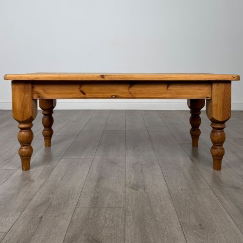 fig 4. A low rectangular pine coffee table featuring turned baluster legs and visible wooden grain across its solid tabletop.