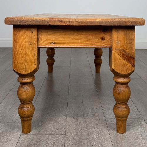 fig 6. A low rectangular pine coffee table featuring turned baluster legs and visible wooden grain across its solid tabletop.
