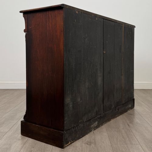 fig 3. A low 19th-century Victorian rosewood open bookcase with two wide shelves, carved acanthus leaf capitals, and a solid plinth base.