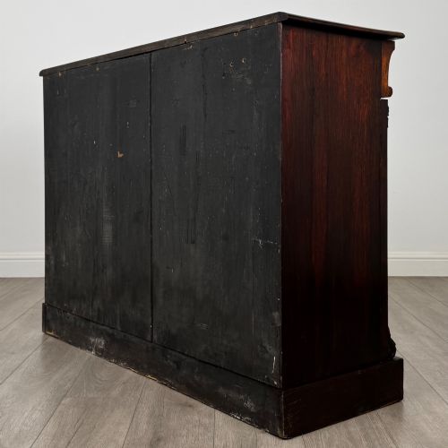 fig 5. A low 19th-century Victorian rosewood open bookcase with two wide shelves, carved acanthus leaf capitals, and a solid plinth base.