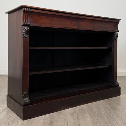 fig 7. A low 19th-century Victorian rosewood open bookcase with two wide shelves, carved acanthus leaf capitals, and a solid plinth base.