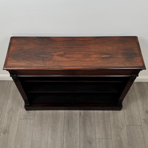 fig 8. A low 19th-century Victorian rosewood open bookcase with two wide shelves, carved acanthus leaf capitals, and a solid plinth base.