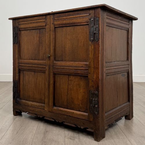fig 2. A seventeenth-century oak cupboard featuring two panelled doors with moulded trim and hand-forged iron hinges.