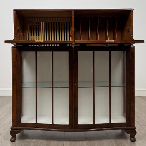 fig 1. A 20th-century figured walnut fitted cabinet featuring upper solid doors above lower glazed doors with glass shelving.
