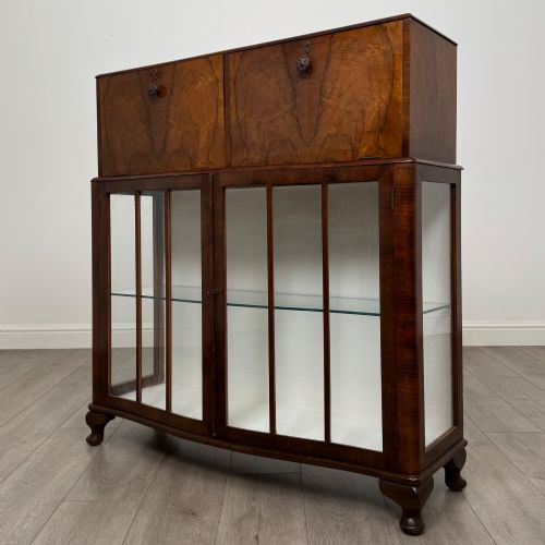 fig 3. A 20th-century figured walnut fitted cabinet featuring upper solid doors above lower glazed doors with glass shelving.