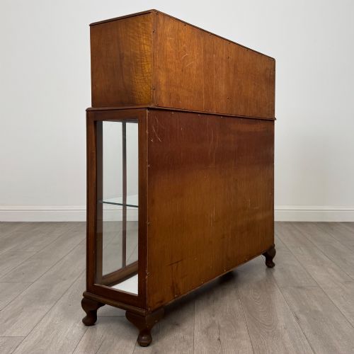 fig 4. A 20th-century figured walnut fitted cabinet featuring upper solid doors above lower glazed doors with glass shelving.