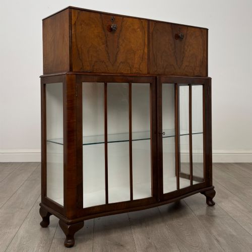 fig 7. A 20th-century figured walnut fitted cabinet featuring upper solid doors above lower glazed doors with glass shelving.