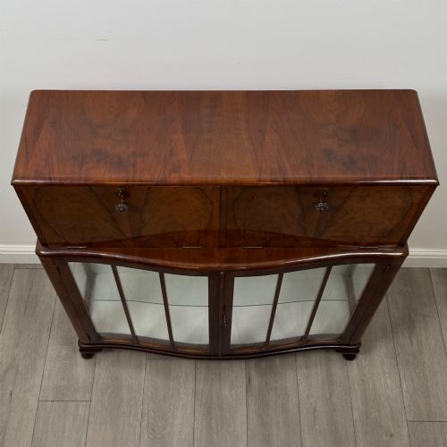 fig 8. A 20th-century figured walnut fitted cabinet featuring upper solid doors above lower glazed doors with glass shelving.