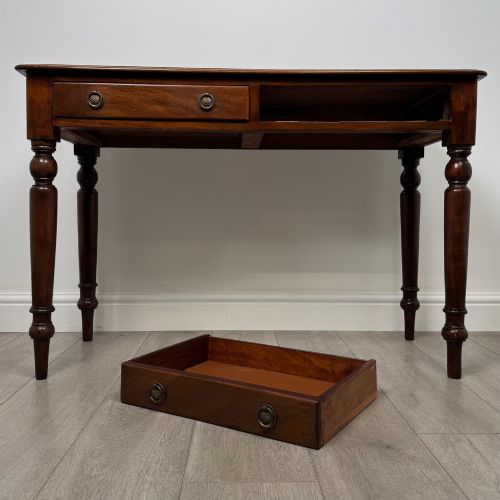 fig 9. A Victorian mahogany writing table featuring two frieze drawers with brass ring handles and four turned legs.