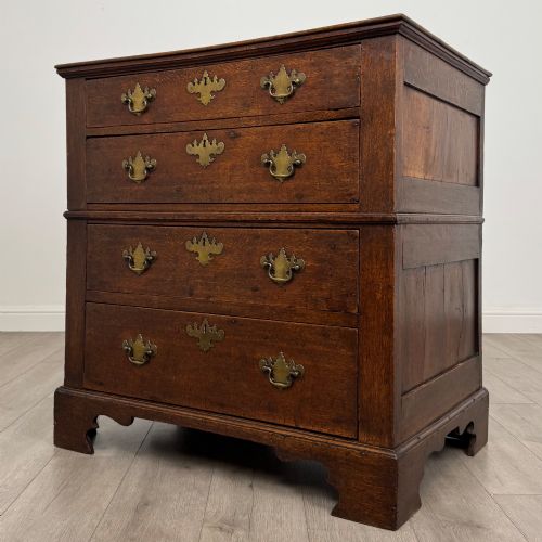fig 1. A seventeenth-century William and Mary oak chest of drawers featuring four drawers with brass escutcheons and drop handles raised on bracket feet.