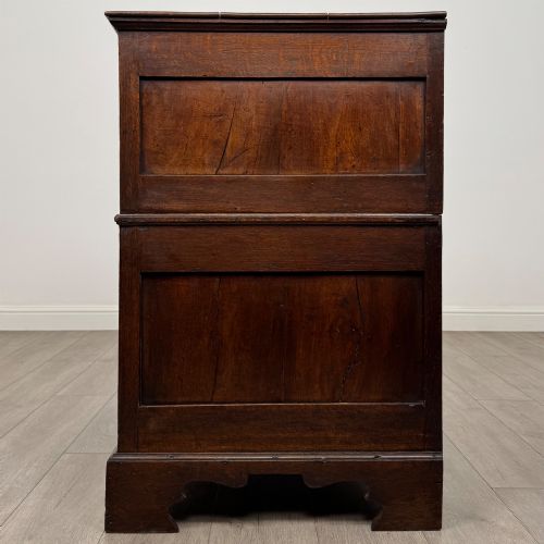 fig 2. A seventeenth-century William and Mary oak chest of drawers featuring four drawers with brass escutcheons and drop handles raised on bracket feet.