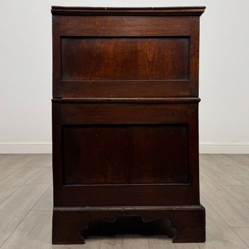 fig 6. A seventeenth-century William and Mary oak chest of drawers featuring four drawers with brass escutcheons and drop handles raised on bracket feet.