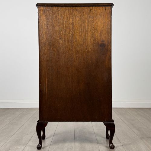fig 4. An antique mahogany display cabinet featuring a single door with geometric astragal glazing bars, glass shelves, and cabriole legs.