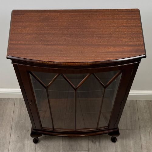 fig 8. An antique mahogany display cabinet featuring a single door with geometric astragal glazing bars, glass shelves, and cabriole legs.