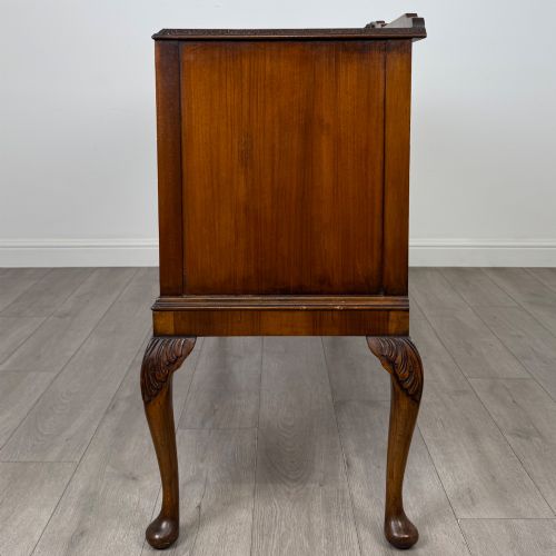 fig 3. A 20th-century burr walnut sideboard featuring three central bowfront drawers flanked by cupboard doors, supported on carved cabriole legs.