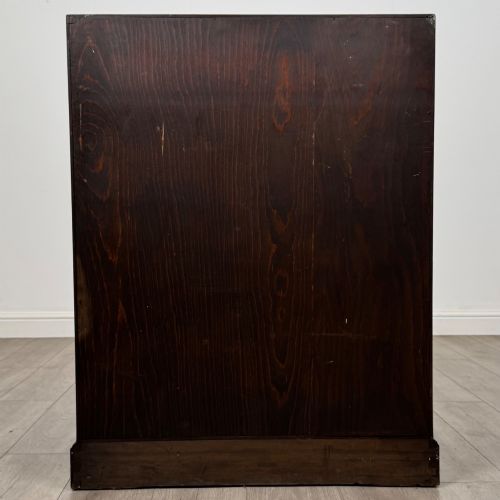 fig 5. A dark oak Jacobean style slant-front bureau featuring geometric inlaid panels and four drawer fronts with turned wooden knobs.