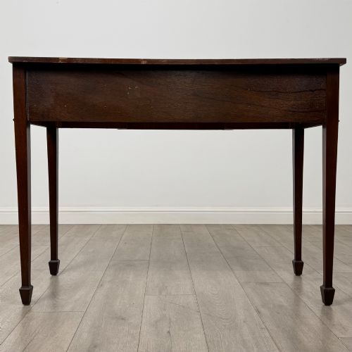 fig 4. A dark mahogany 20th-century Adam style side table featuring a central carved urn motif, fluted frieze drawers, brass ring handles, and square tapered legs ending in spade feet.