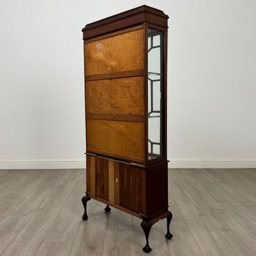 fig 6. An early 20th-century mahogany glazed display cabinet featuring geometric astragal doors, marquetry inlaid lower cupboards, and cabriole legs.