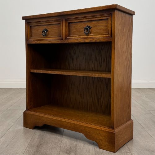 fig 1. A small 20th-century open oak bookcase featuring two drawers at the top with dark twisted ring handles above two open shelves.