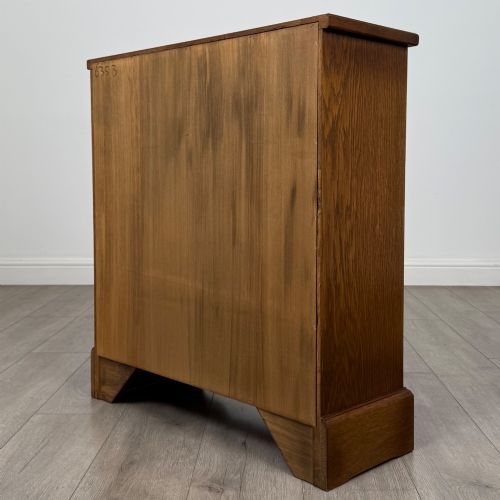 fig 5. A small 20th-century open oak bookcase featuring two drawers at the top with dark twisted ring handles above two open shelves.