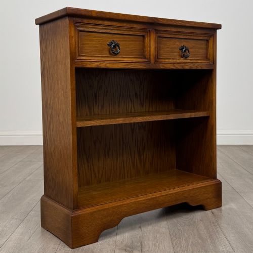 fig 7. A small 20th-century open oak bookcase featuring two drawers at the top with dark twisted ring handles above two open shelves.