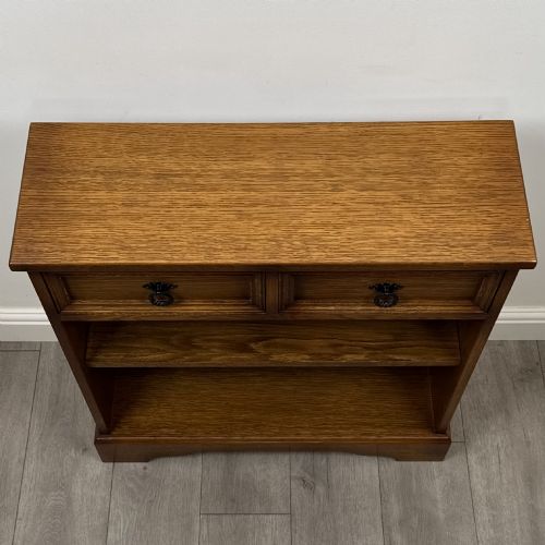 fig 8. A small 20th-century open oak bookcase featuring two drawers at the top with dark twisted ring handles above two open shelves.