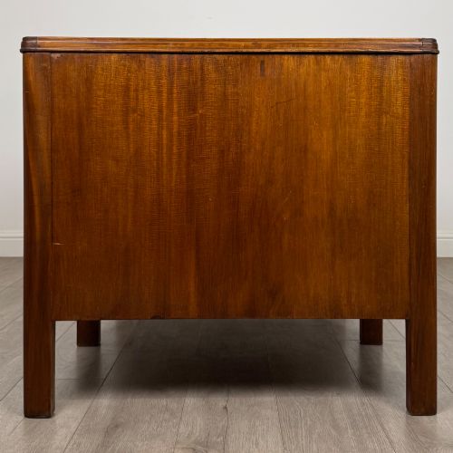 fig 6. A large mid-20th century mahogany pedestal desk featuring two sets of drawers with brass drop handles and a central kneehole.