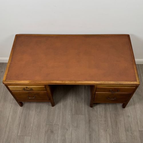 fig 8. A large mid-20th century mahogany pedestal desk featuring two sets of drawers with brass drop handles and a central kneehole.