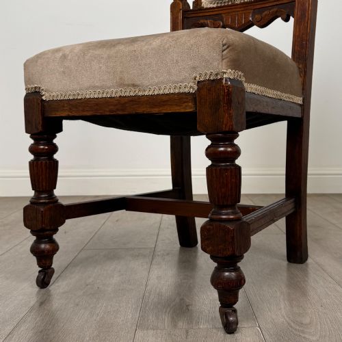fig 4. A set of four 19th-century Victorian carved oak dining chairs featuring beige upholstered seats, turned legs, and detailed crest carved backrests.