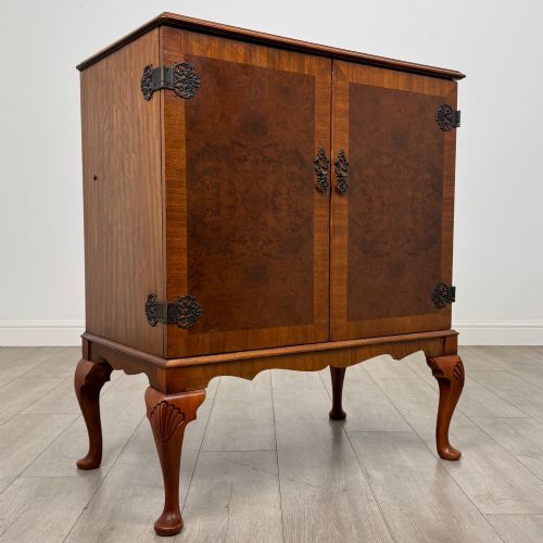 fig 8. A 20th-century burr walnut two-door fitted cabinet on cabriole legs with carved shell knees and decorative pierced brass hinges.