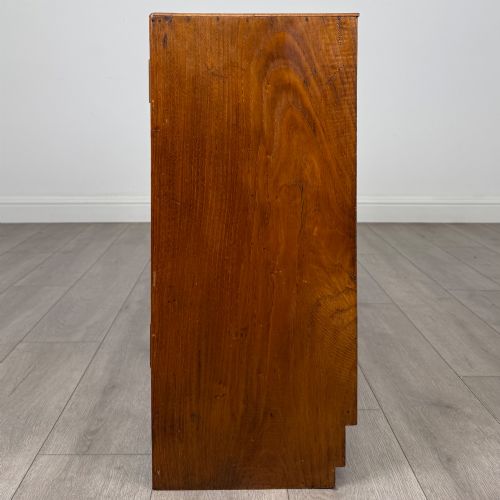 fig 3. A compact golden oak sideboard featuring four shallow drawers on the left, an open shelf below, and a slatted single door cabinet on the right.