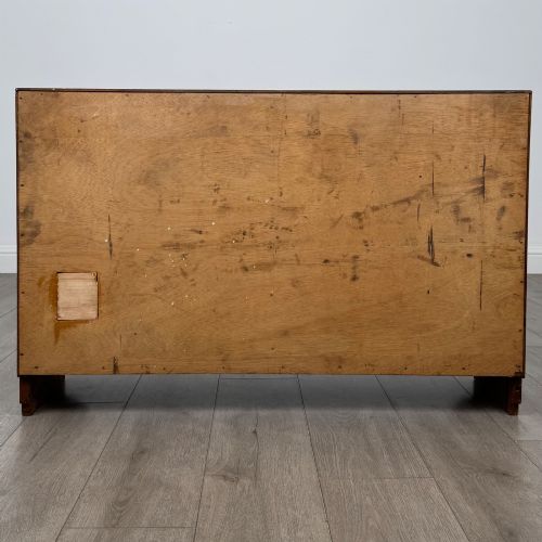 fig 5. A compact golden oak sideboard featuring four shallow drawers on the left, an open shelf below, and a slatted single door cabinet on the right.