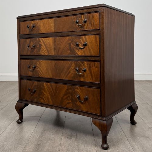fig 1. A mahogany chest of drawers featuring four full-width drawers with flame veneer fronts, brass handles, and cabriole legs.