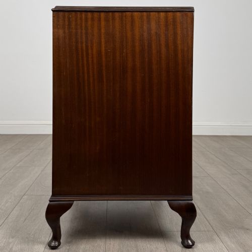 fig 2. A mahogany chest of drawers featuring four full-width drawers with flame veneer fronts, brass handles, and cabriole legs.