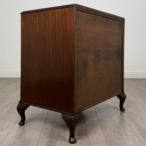 fig 3. A mahogany chest of drawers featuring four full-width drawers with flame veneer fronts, brass handles, and cabriole legs.