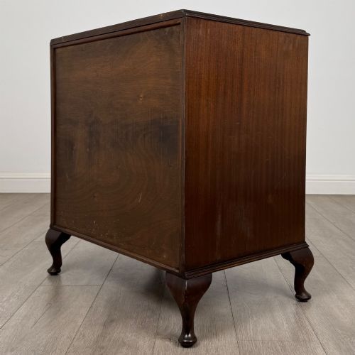 fig 5. A mahogany chest of drawers featuring four full-width drawers with flame veneer fronts, brass handles, and cabriole legs.