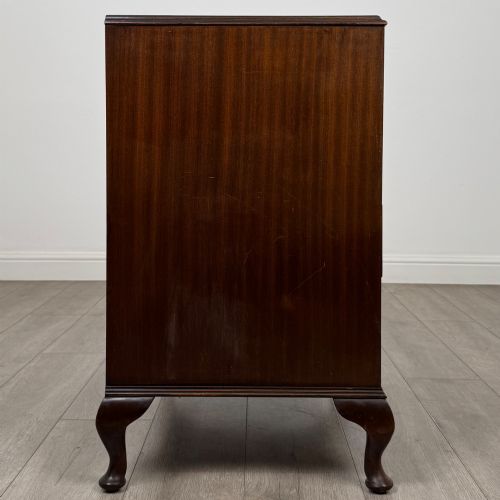fig 6. A mahogany chest of drawers featuring four full-width drawers with flame veneer fronts, brass handles, and cabriole legs.