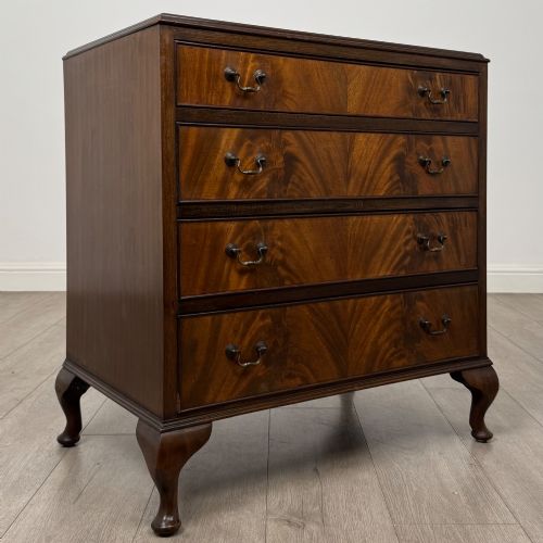fig 7. A mahogany chest of drawers featuring four full-width drawers with flame veneer fronts, brass handles, and cabriole legs.