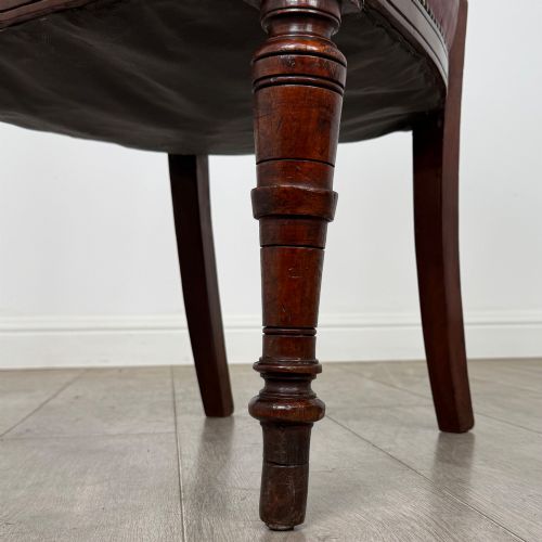 fig 5. A set of four 19th-century mahogany dining chairs featuring carved open backs, dark red leather upholstered seats with stud trim, and turned front legs.